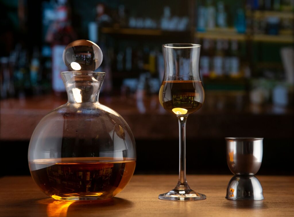 Decantador y copa de brandy sobre una barra de madera
